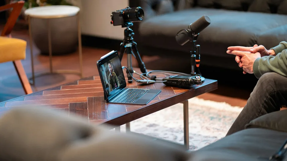 A camera, microphones and a laptop are arranged in a video recording studio.