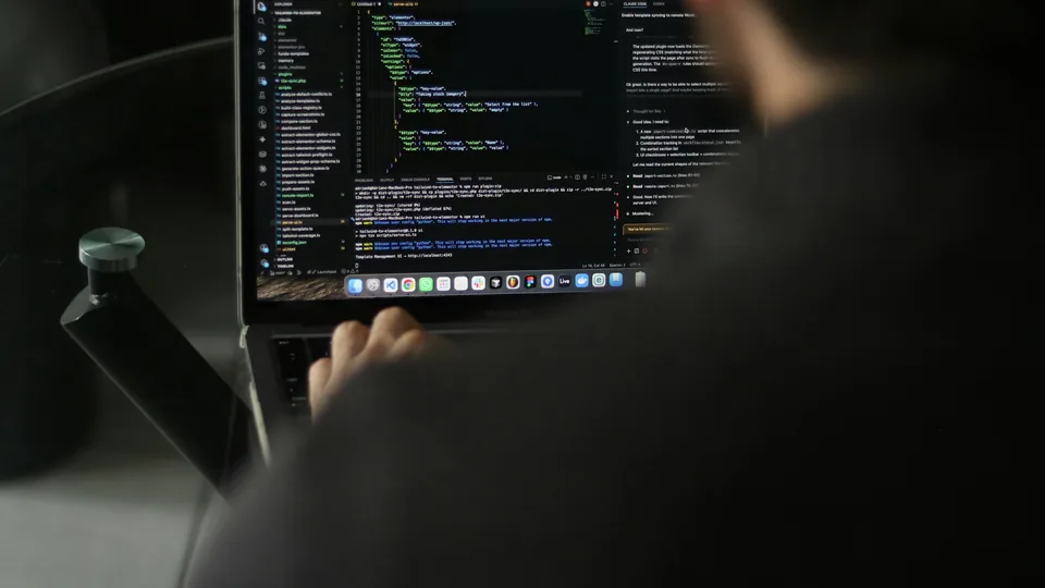 A developer types code on a laptop; this is a real work photo, not a WordPress interface screenshot.
